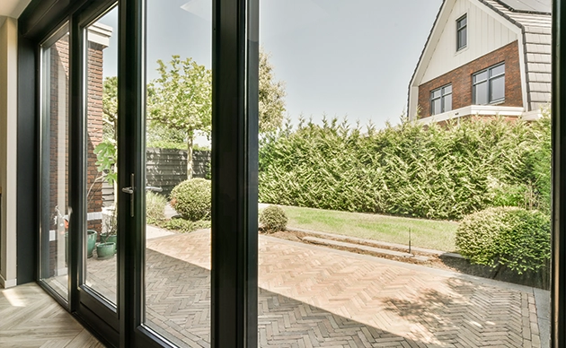 Technician adjusting rollers on a patio sliding glass door track