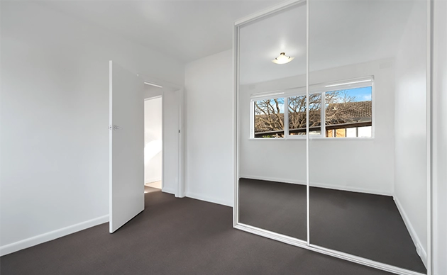 Clean sliding glass door opening onto backyard patio with desert landscaping